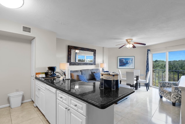 kitchen featuring dishwasher, sink, white cabinets, light tile patterned floors, and kitchen peninsula