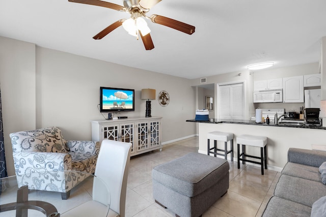 tiled living room featuring ceiling fan