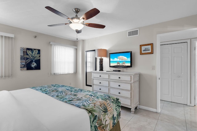 tiled bedroom featuring ceiling fan