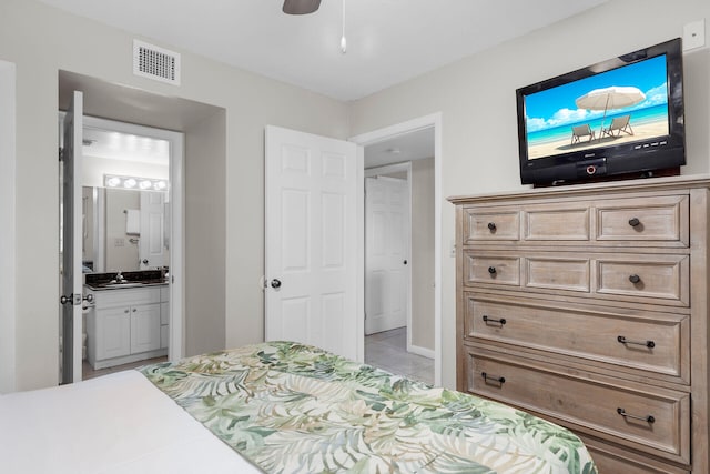 tiled bedroom with sink, ceiling fan, and ensuite bathroom