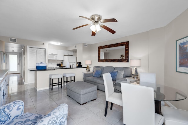 tiled living room featuring ceiling fan