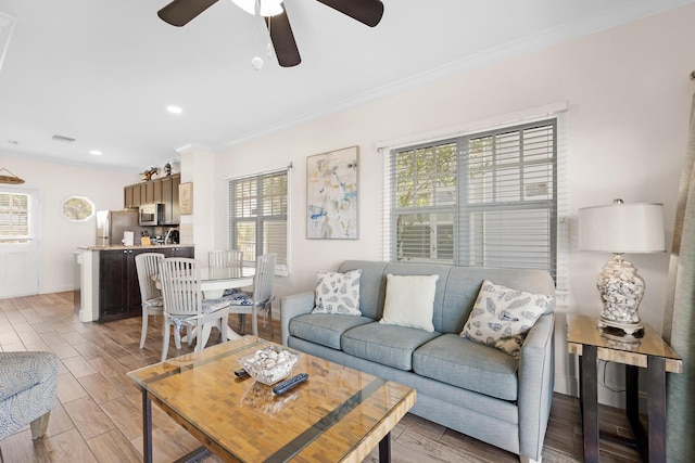 living room featuring ornamental molding and ceiling fan