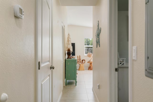 corridor with light tile patterned floors and baseboards