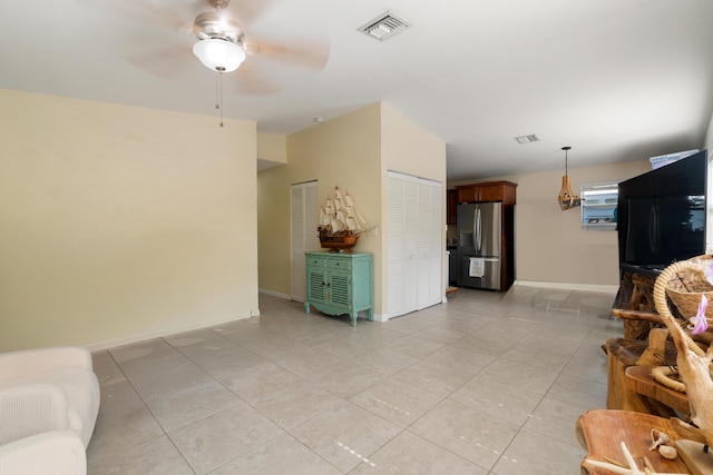 living room featuring light tile patterned flooring, ceiling fan, and baseboards