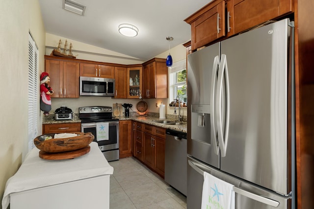 kitchen with appliances with stainless steel finishes, a sink, lofted ceiling, glass insert cabinets, and light tile patterned floors