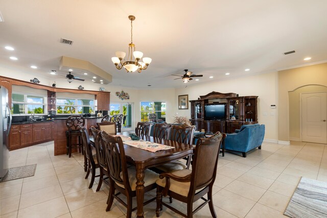 tiled dining area with ceiling fan with notable chandelier, sink, and ornamental molding