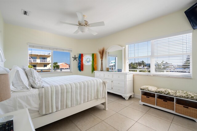 bedroom featuring multiple windows, ceiling fan, and light tile patterned floors