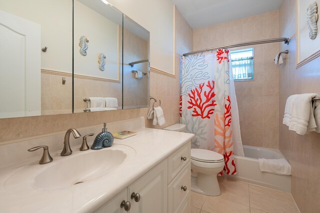 full bathroom with tile patterned flooring, toilet, tile walls, shower / bath combination with curtain, and vanity