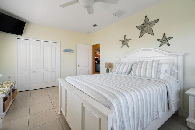 bedroom with light tile patterned floors, ceiling fan, and a closet