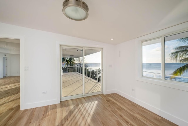 spare room featuring wood-type flooring and a water view