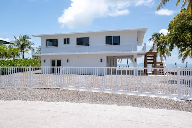 view of front of house with a carport, a water view, and french doors