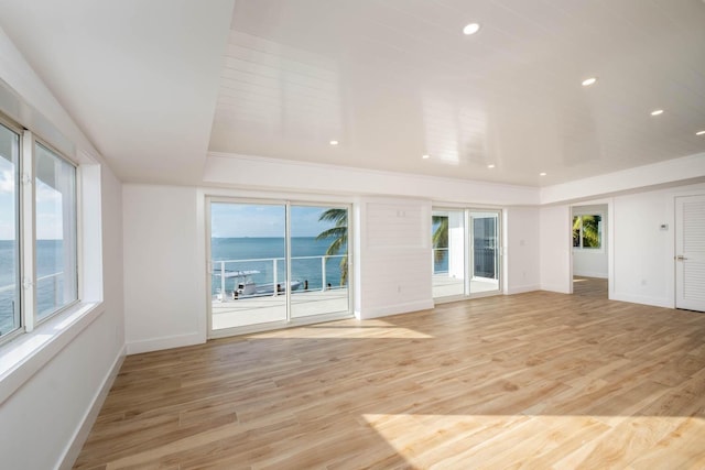 interior space with light hardwood / wood-style floors and a water view