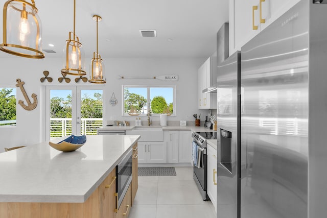 kitchen with white cabinetry, pendant lighting, a center island, and appliances with stainless steel finishes