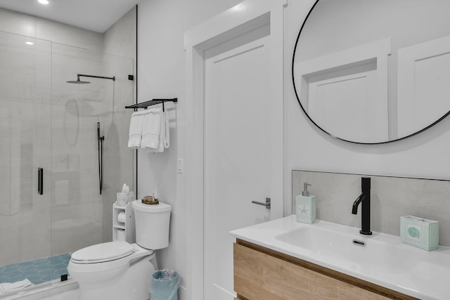 bathroom with vanity, a shower with shower door, and toilet