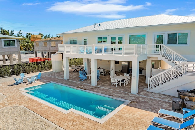 rear view of property with a balcony and a patio area