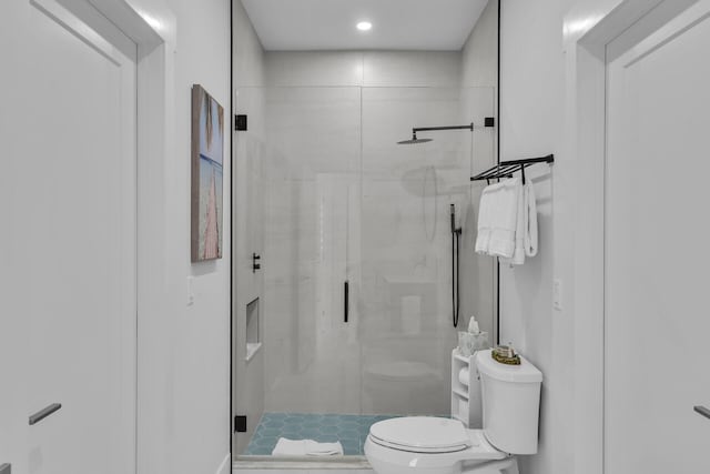 bathroom with toilet and a shower with shower door