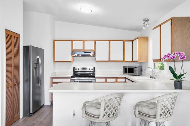 kitchen featuring a breakfast bar area, kitchen peninsula, and appliances with stainless steel finishes