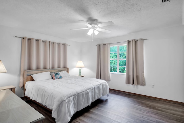 bedroom featuring dark wood-type flooring, ceiling fan, and a textured ceiling