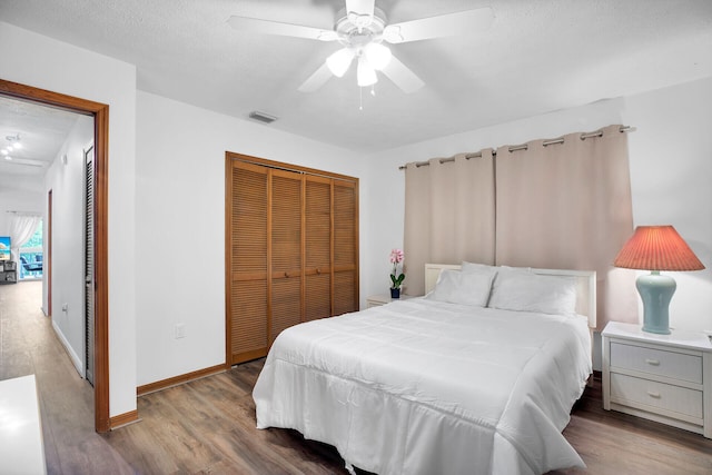 bedroom with ceiling fan, hardwood / wood-style flooring, a closet, and a textured ceiling