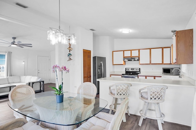 dining room featuring vaulted ceiling, dark hardwood / wood-style floors, and ceiling fan