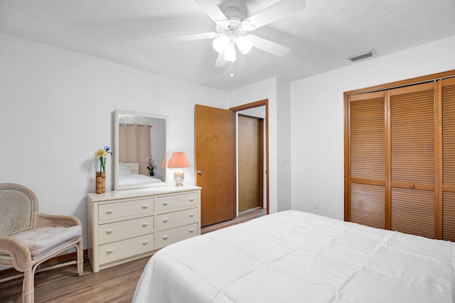 bedroom featuring ceiling fan, hardwood / wood-style floors, and a closet