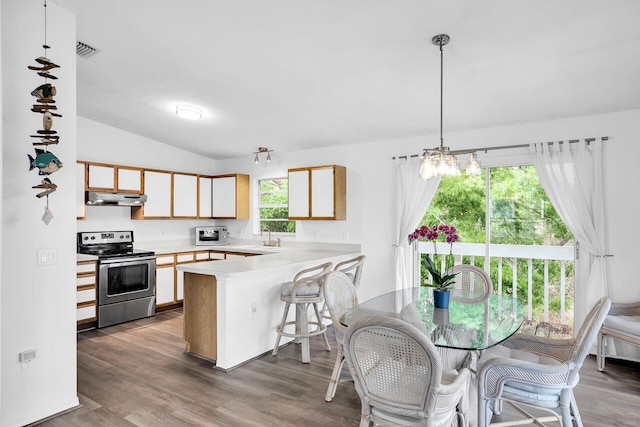 kitchen featuring stainless steel range with electric cooktop, wood-type flooring, a kitchen breakfast bar, kitchen peninsula, and pendant lighting