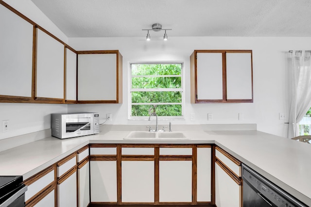 kitchen featuring black dishwasher, sink, white cabinets, and a textured ceiling