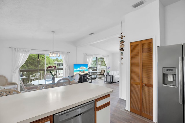 kitchen with hardwood / wood-style flooring, stainless steel fridge, dishwasher, hanging light fixtures, and lofted ceiling with beams