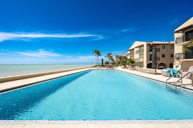 view of pool with a patio area and a water view