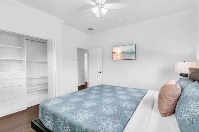 bedroom with crown molding, dark wood-type flooring, a closet, and ceiling fan