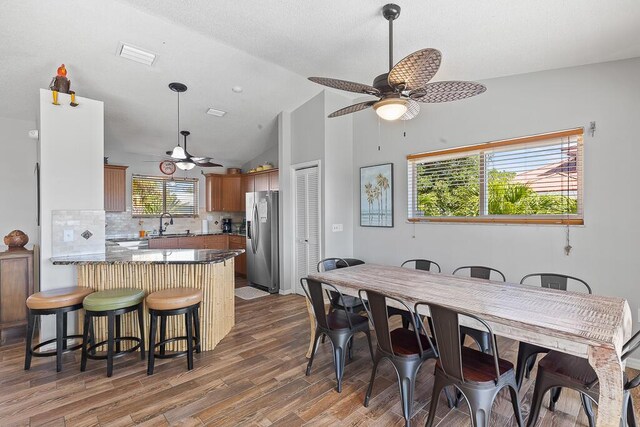 dining room with lofted ceiling, sink, dark hardwood / wood-style floors, and ceiling fan