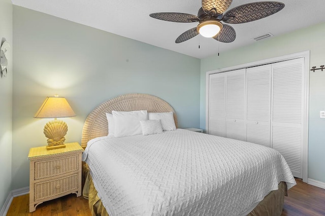 bedroom with dark hardwood / wood-style floors, ceiling fan, and a closet