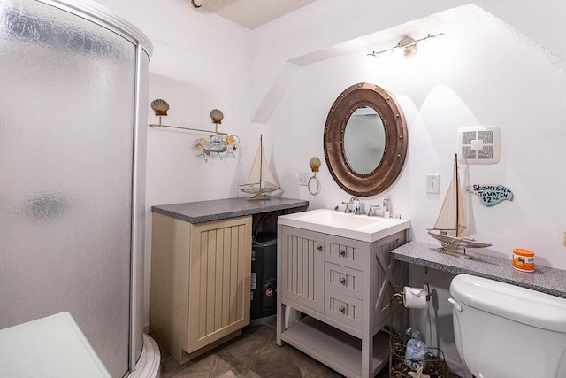 bathroom with an enclosed shower, vanity, and toilet