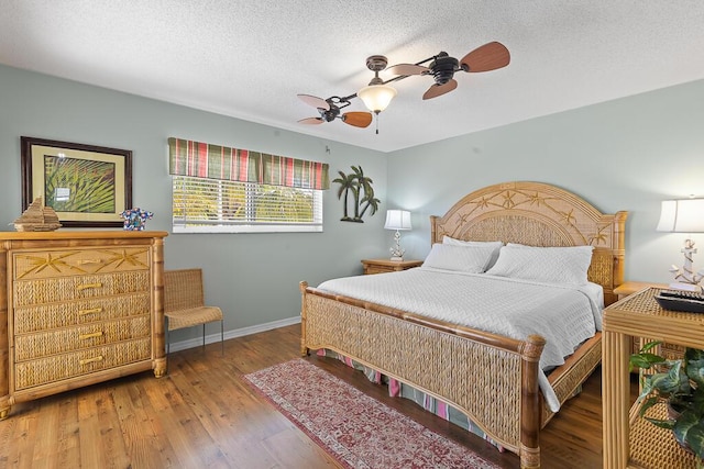 bedroom with hardwood / wood-style flooring, ceiling fan, and a textured ceiling