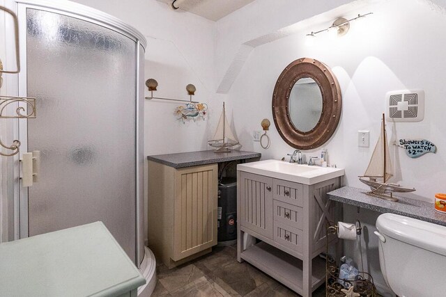 bathroom featuring vanity, an enclosed shower, and toilet