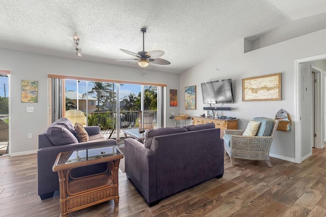 living room featuring dark wood-type flooring, vaulted ceiling, and a textured ceiling