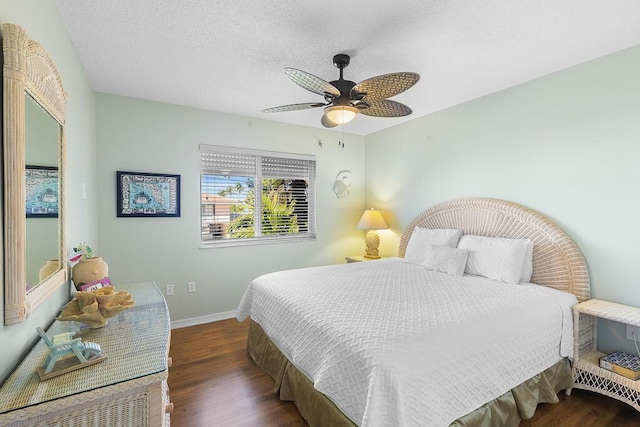 bedroom with dark wood-type flooring, ceiling fan, and a textured ceiling