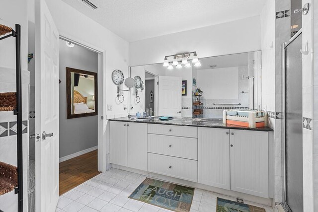 bathroom featuring vanity, a shower with door, and tile patterned floors