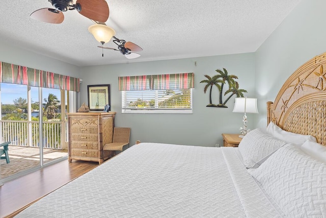 bedroom with hardwood / wood-style floors, access to outside, a textured ceiling, and ceiling fan