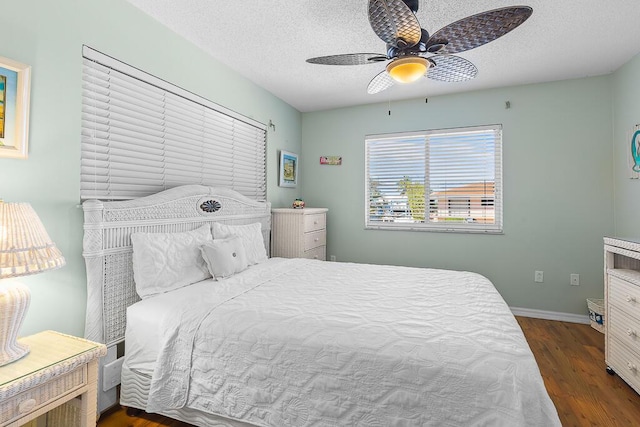 bedroom featuring ceiling fan, dark hardwood / wood-style floors, and a textured ceiling