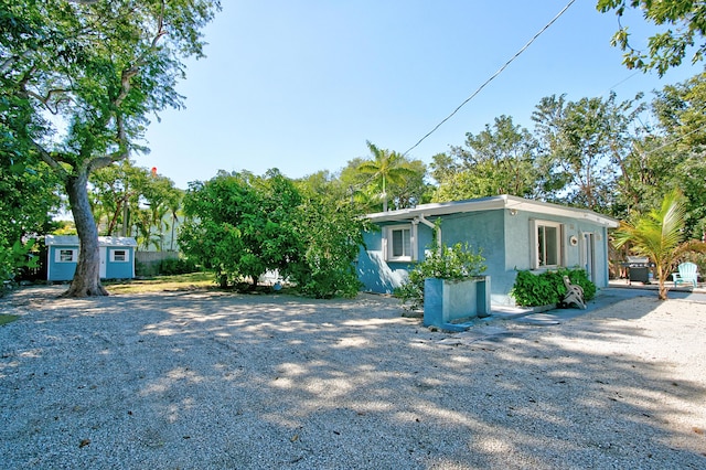 view of side of property featuring an outbuilding and stucco siding