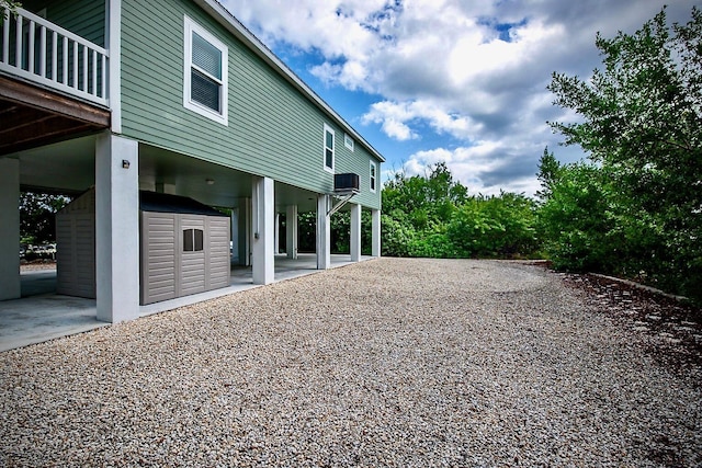 view of yard with a patio area, a balcony, and a storage unit