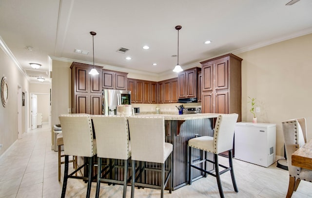 kitchen with pendant lighting, fridge, ornamental molding, a kitchen bar, and stainless steel fridge with ice dispenser