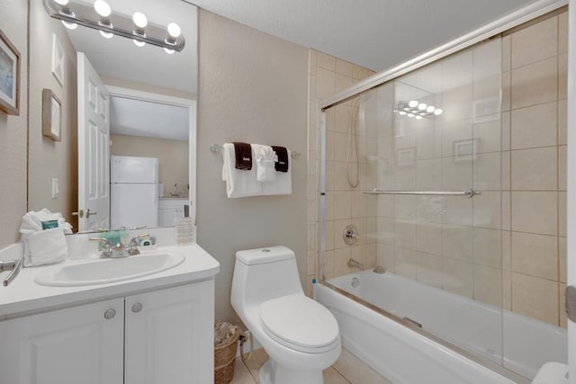 full bathroom with bath / shower combo with glass door, vanity, a textured ceiling, tile patterned floors, and toilet