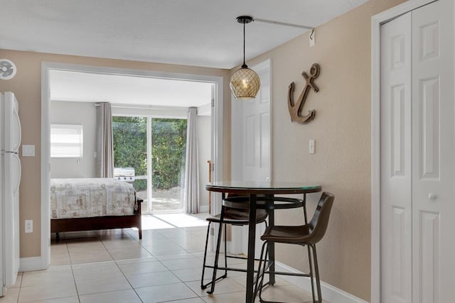 bedroom featuring white refrigerator, access to outside, and light tile patterned floors