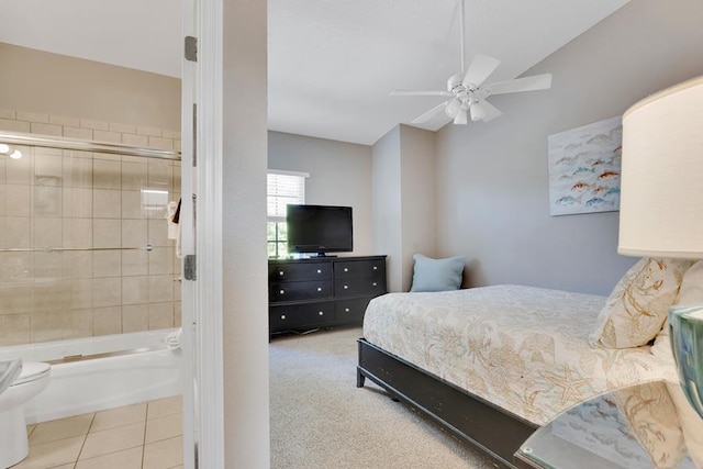 tiled bedroom featuring ceiling fan, ensuite bathroom, and lofted ceiling