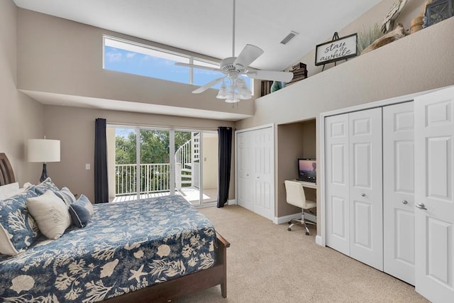 bedroom featuring multiple closets, light carpet, a high ceiling, and access to outside