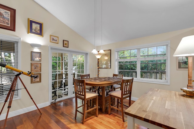 dining room featuring french doors, vaulted ceiling, and hardwood / wood-style floors