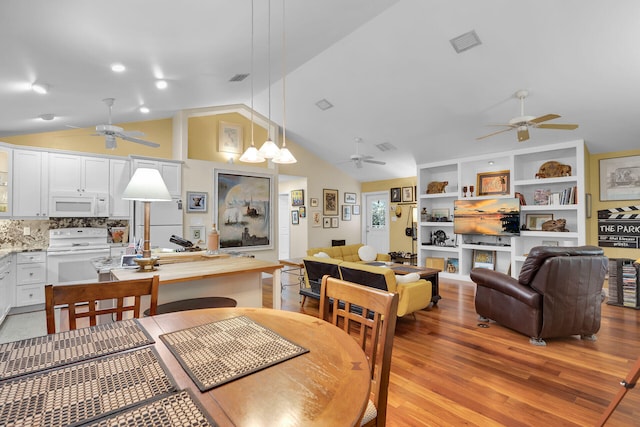 dining room featuring lofted ceiling and light wood-type flooring