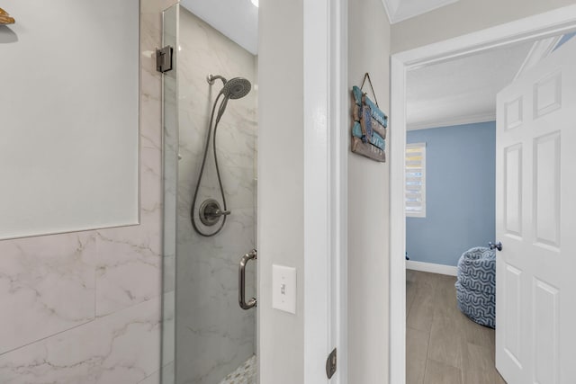 bathroom with crown molding and a shower with shower door